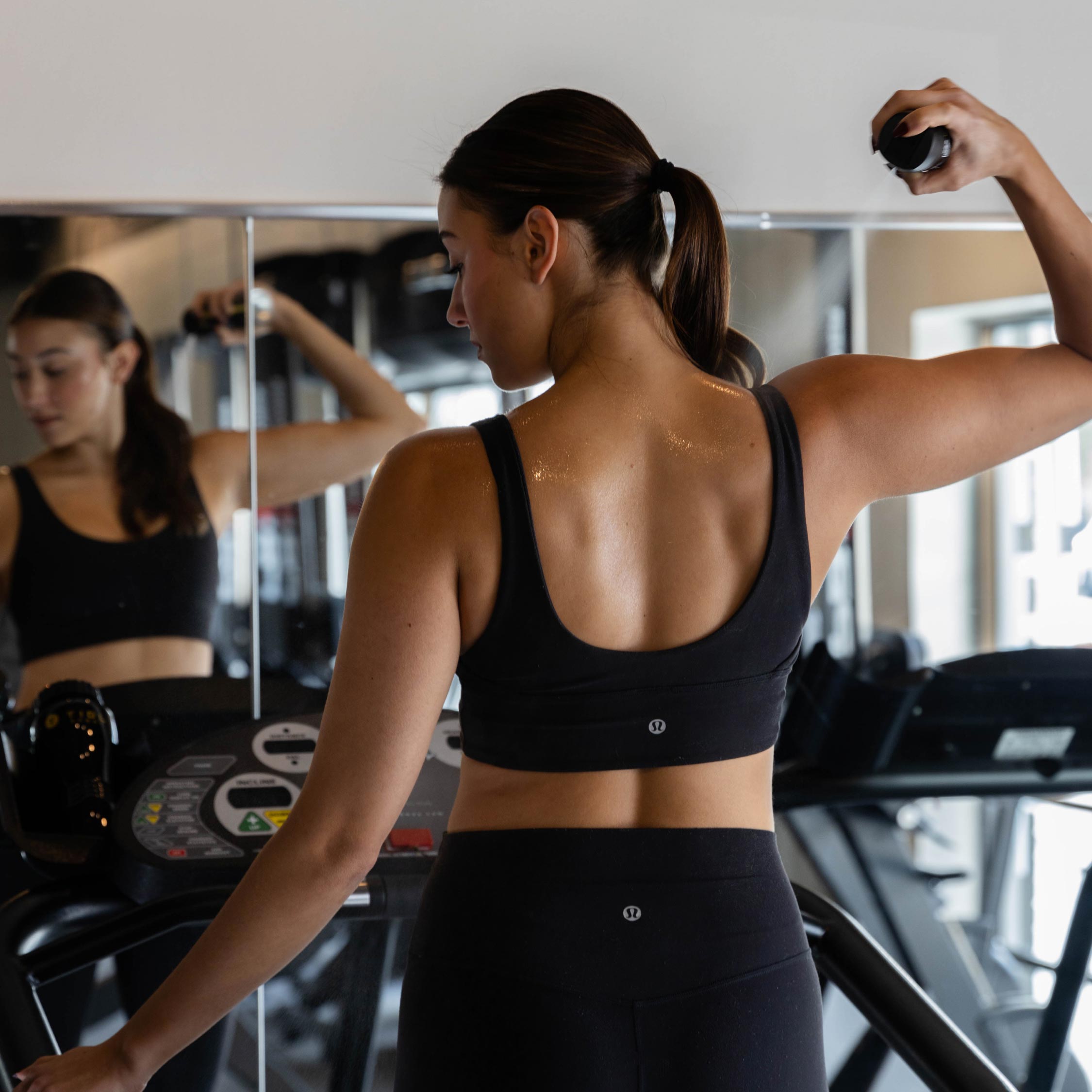 Woman using a treadmill while looking at her reflection in the mirror.
